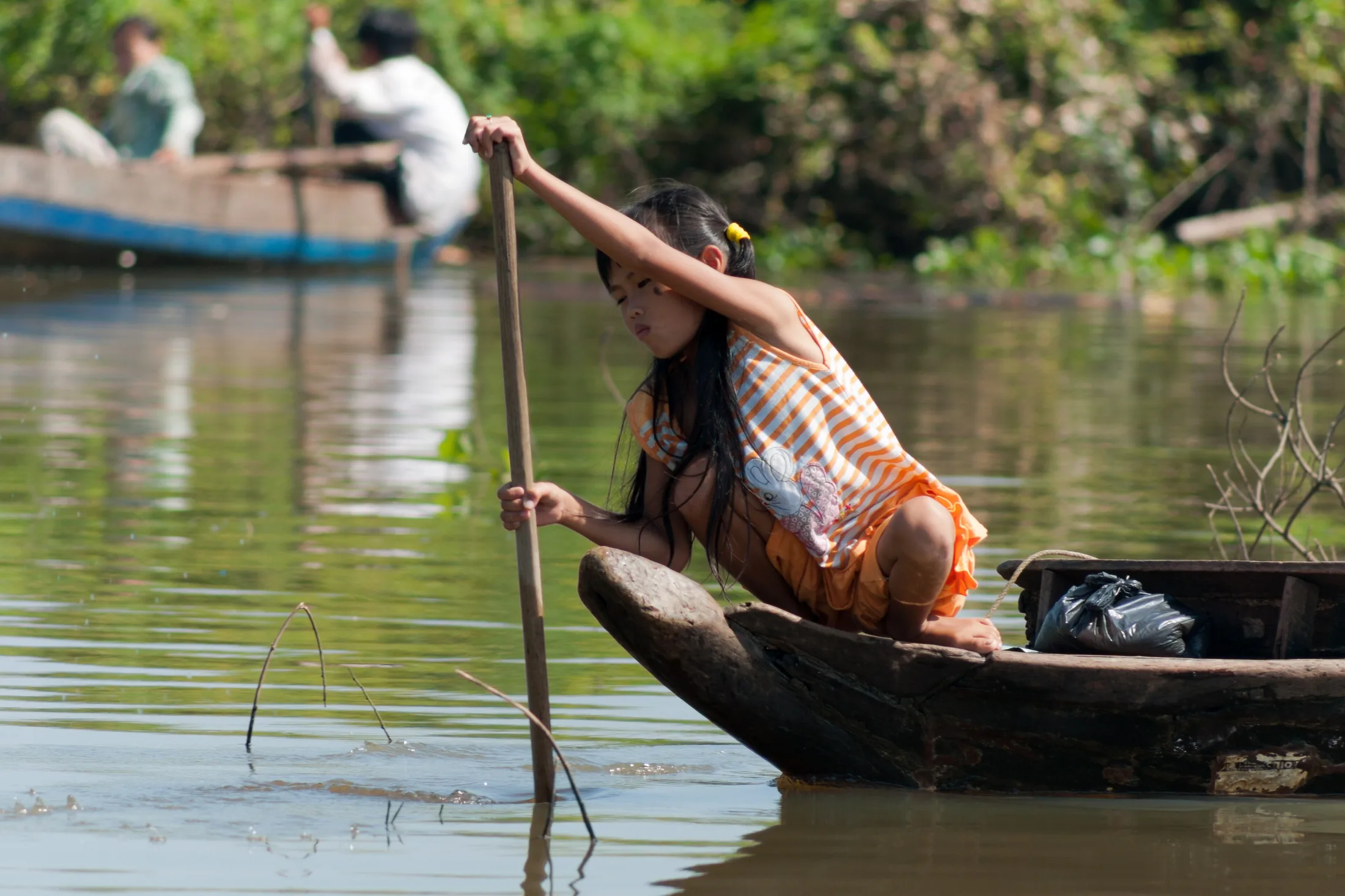 Tonle Sap Siem Reap Cambodia Girl-steering-her-boat-01 in or near Siem Reap, Cambodia